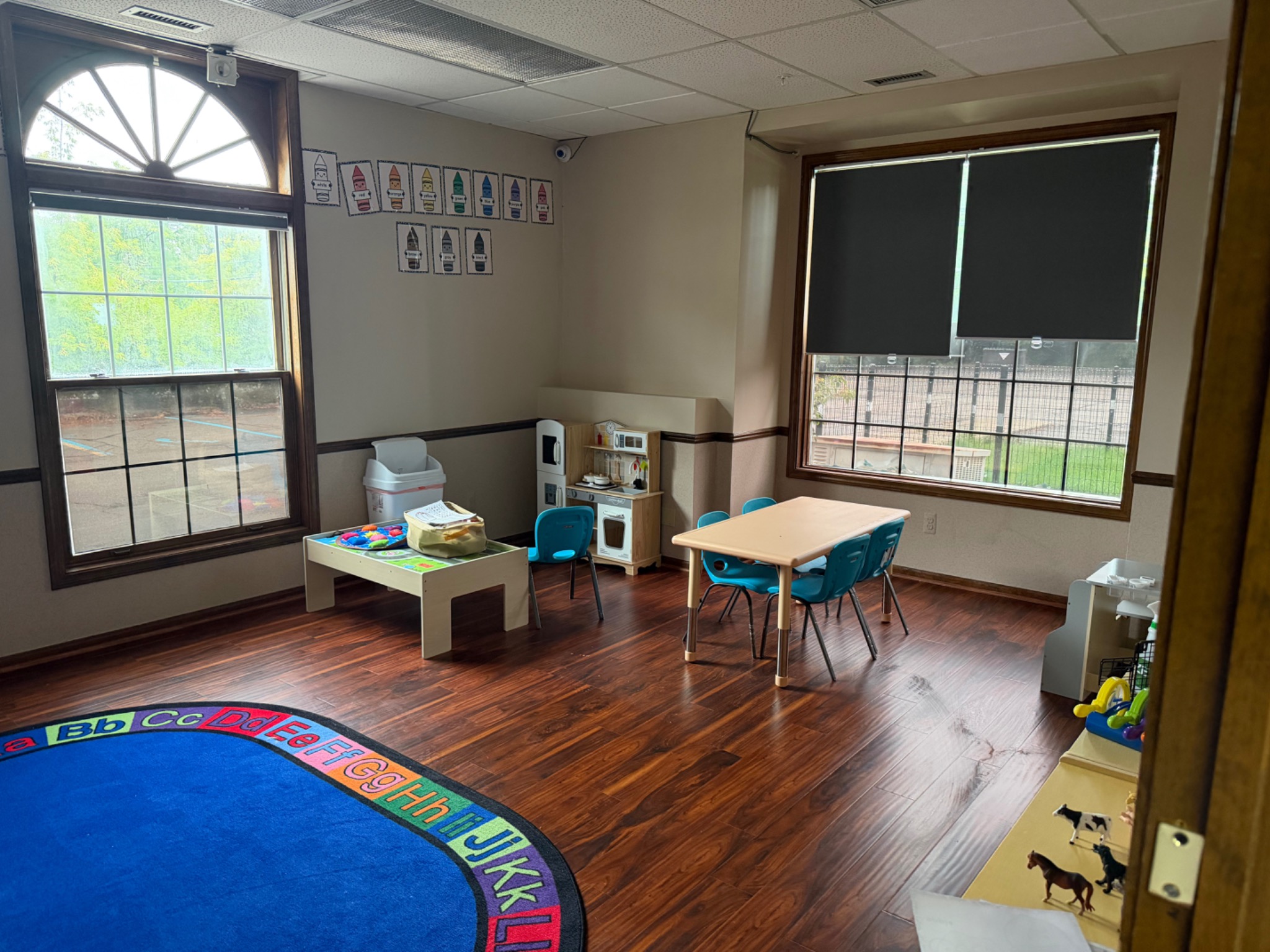 Bright classroom with a colorful alphabet rug and child-sized learning areas