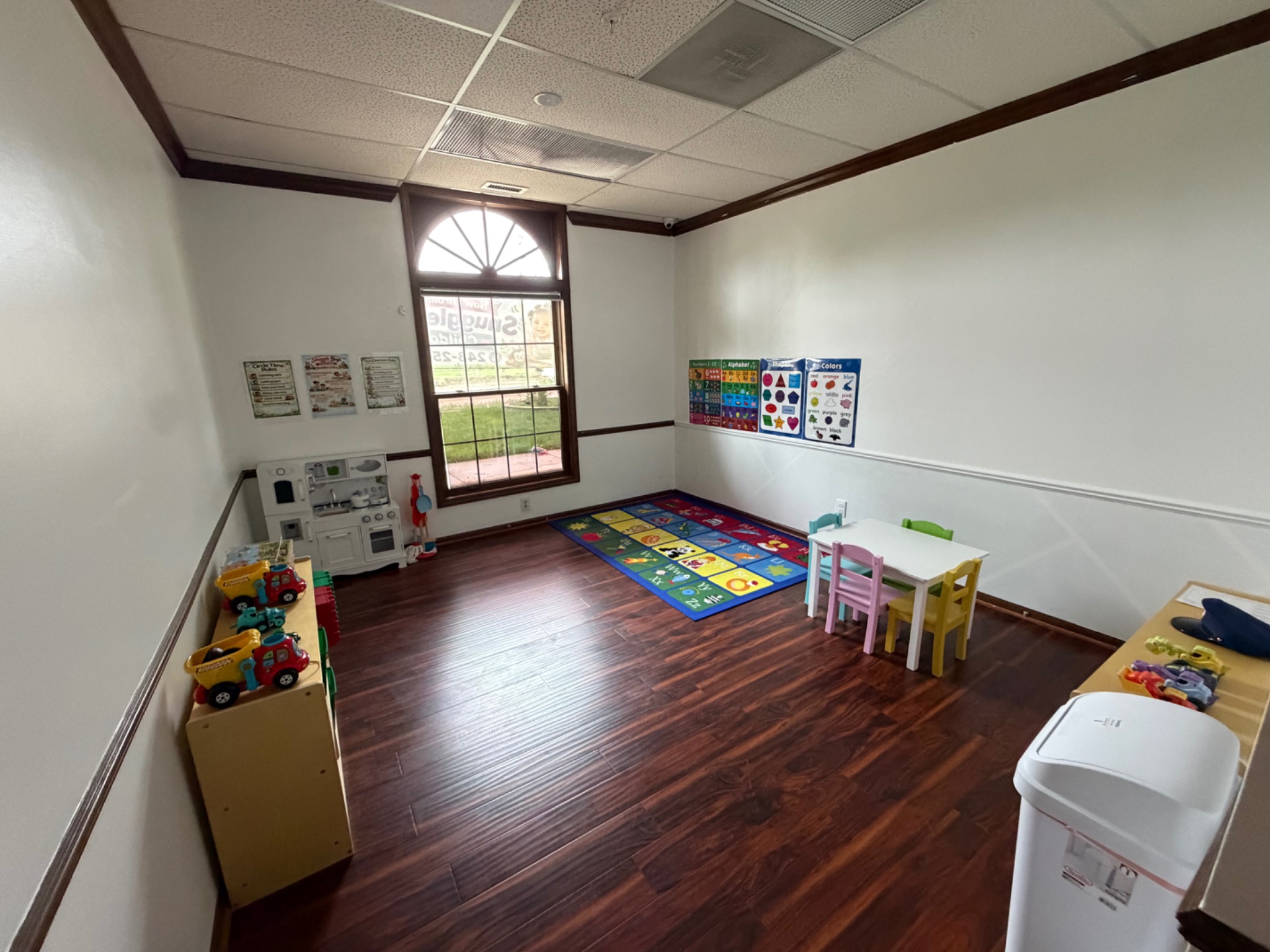 Open classroom prepared with learning rugs and toys